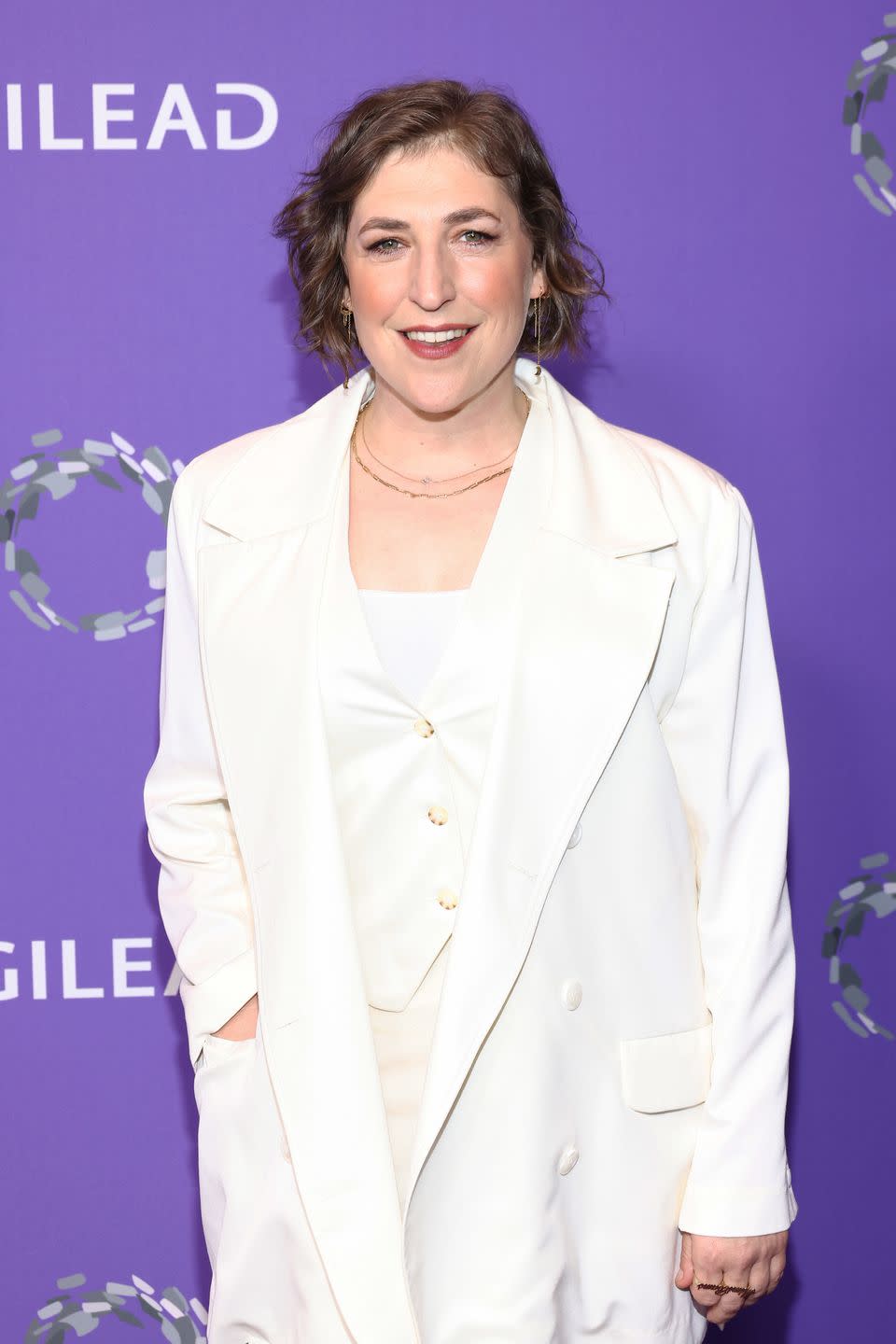 mayim bialik in a white three piece suit with oversized jacket