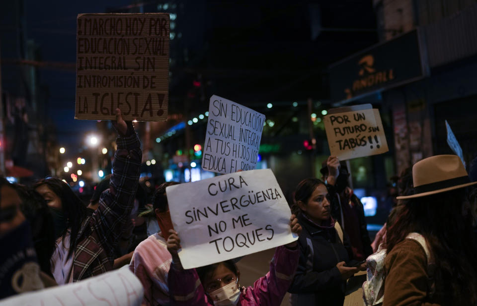 People protest with signs that read in Spanish "Shameless priest do not touch me" and "I march for sexual education without Church interference," outside the offices of the Bolivian Episcopal Conference in La Paz, Bolivia, Monday, May 15, 2023. Bolivia's Jesuit congregation has apologized publicly and is launching an investigation into a late Spanish priest who allegedly abused several minors in Bolivia dating back to the 1980s. (AP Photo/Juan Karita)