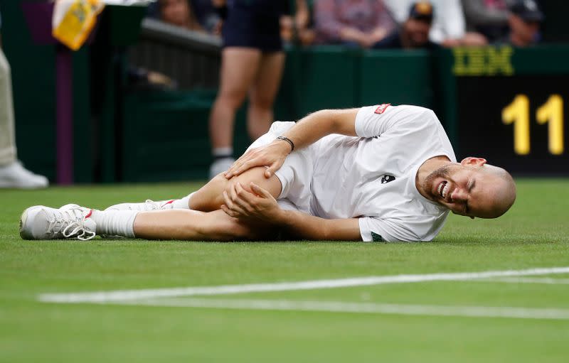 Adrian Mannarino, caído después de sufrir una lesión en el partido contra Roger Federer