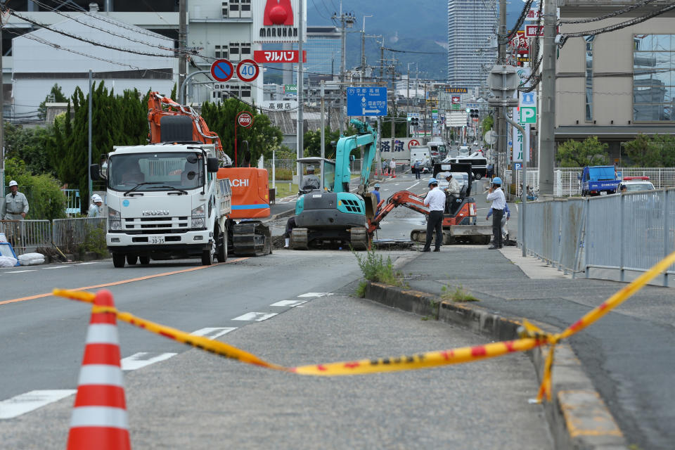 <p>Workers fix a sinkhole on a road caused a magnitude 6.1 earthquake in Takatsuki, Osaka, Japan, on Monday, June 18, 2018. (Photo: Buddhika Weerasinghe/Bloomberg via Getty Images) </p>