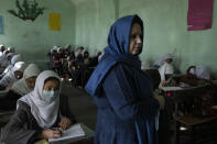 Afghan girls listen their teacher at Tajrobawai Girls High School, in Herat, Afghanistan, Thursday, Nov. 25, 2021. While most high school girls in Afghanistan are forbidden to attend class by the country's Taliban rulers, one major exception are those in the western province of Herat. For weeks, girls there have been attending high school classes, thanks to a unique effort by teachers and parents to persuade local Taliban administrators to allow schools to reopen. (AP Photo/Petros Giannakouris)