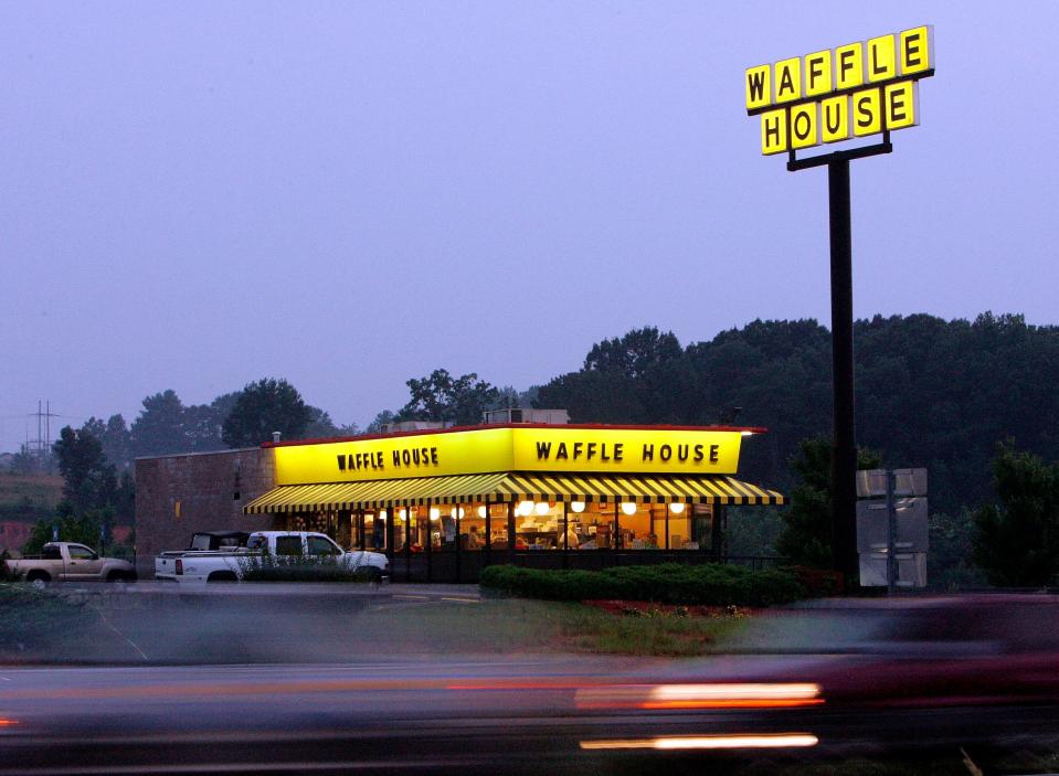 FILE - In this July 28, 2005, file photo, traffic flashes by breakfast diners at a Waffle House near Dawsonville, Ga.  (AP Photo/Ric Feld, File)