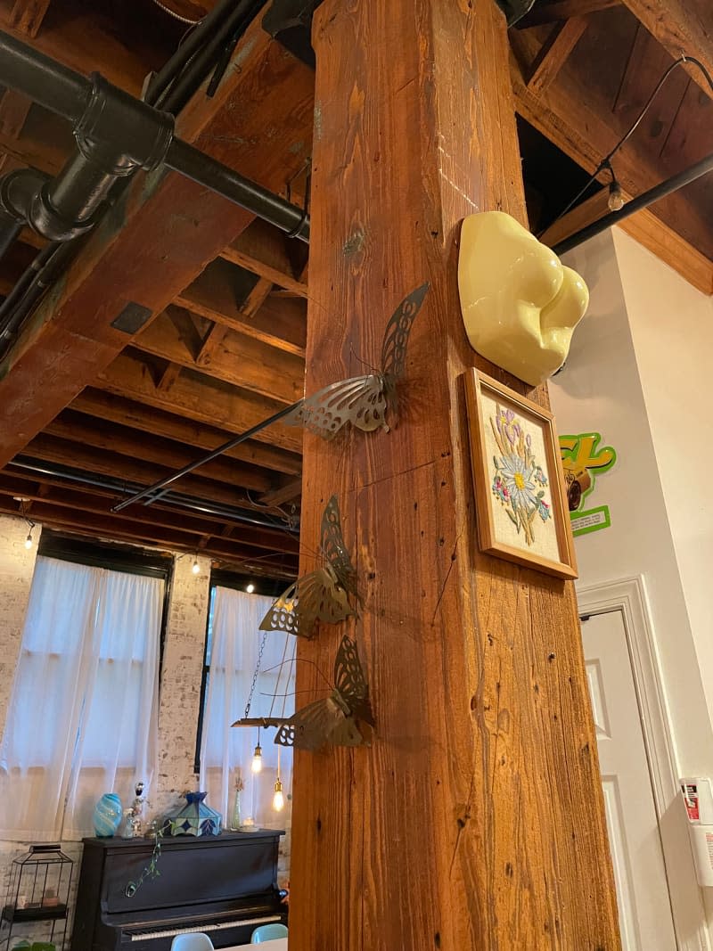 Butterfly sculptures mounted on wooden beam in apartment.