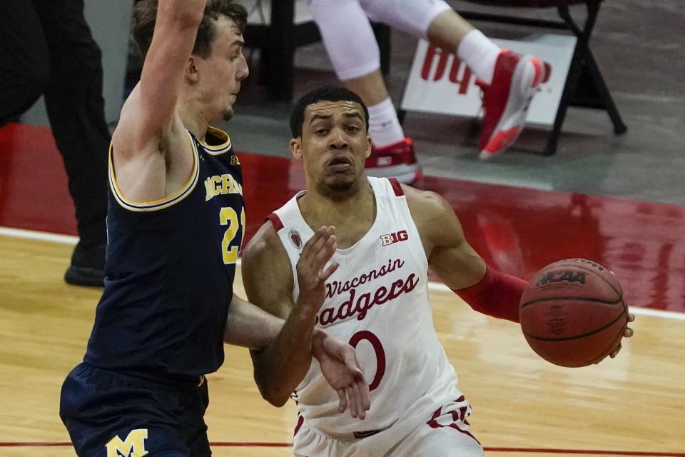 Wisconsin's D'Mitrik Trice drives past Michigan's Franz Wagner during the second half of an NCAA college basketball game Sunday, Feb. 14, 2021, in Madison, Wis. (AP Photo/Morry Gash)