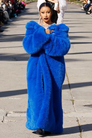 <p>Taylor Hill/Getty </p> Cardi B took the runway in a blue furry coat