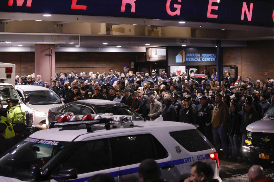 Officers salute a procession as the remains of slain Detective Brian Simonsen are removed from Jamaica Hospital Tuesday, Feb. 12, 2019, in the Queens borough of New York. A NYPD detective and a NYPD sergeant were shot while responding to an armed robbery at a T-Mobile store in Queens. (AP Photo/Kevin Hagen).