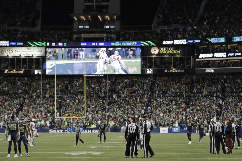 Officials stand on the field as a play involving Seattle Seahawks tight end Jacob Hollister (48) is reviewed late in the second half of an NFL football game against the San Francisco 49ers, Sunday, Dec. 29, 2019, in Seattle. Hollister was ruled down just inches away from the goal line on a fourth-and-goal play and the decision was upheld by the review. The 49ers won 26-21. (AP Photo/Ted S. Warren)