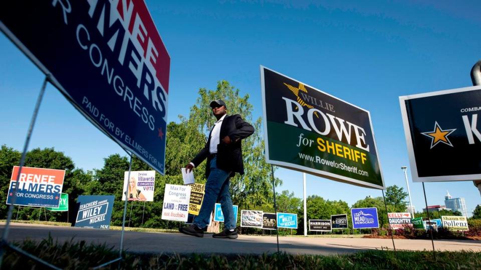 Nathan Click, a Democratic candidate for North Carolinaís 13th Congressional District, walks by campaign signs outside of the John Chavis Memorial Park Community Center polling site on Tuesday, May 17, 2022, in Raleigh, N.C.