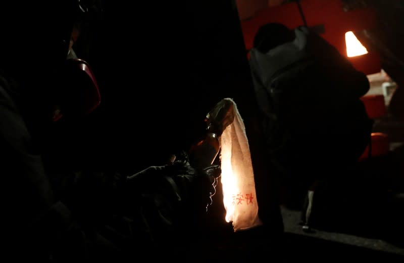 A protester lights up a molotov cocktail during a standoff with riot police at the Chinese University of Hong Kong