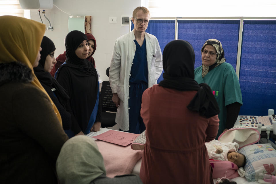 Dr. Vitaly Dedovich, of the Novick Cardiac Alliance medical team, center, and Dr. Hanifa Alrabti, right, talk to a patient's mother at the Tajoura National Heart Center in Tripoli, Libya, on Feb. 24, 2020. Novick’s group not only drops in a few times a year, but also trains Libyan doctors and nurses to build up the country’s critical health care system. (AP Photo/Felipe Dana)