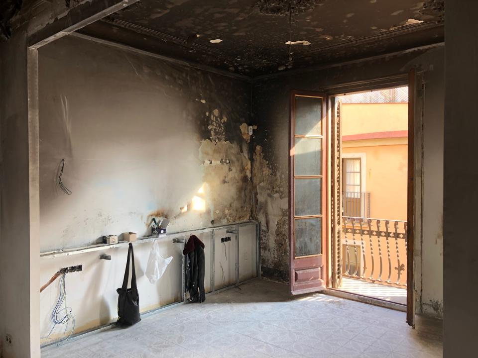 Before: Smoke damage from the fire covered most of the walls and original ceiling of the unit, which is set on the top floor of an Art Nouveau building in the El Born neighborhood.