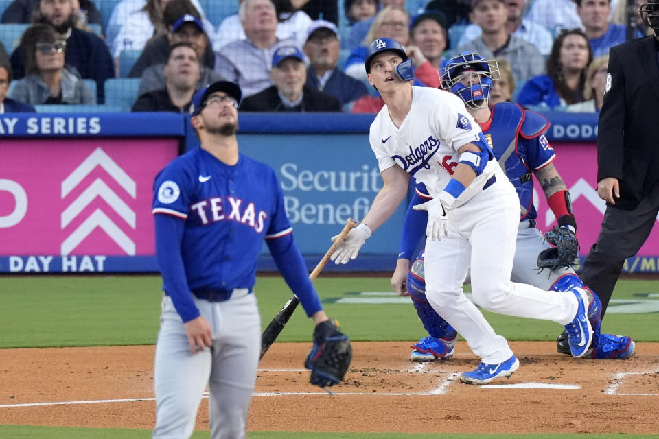 Los Angeles Dodgers' Will Smith, center, heads to first for a three-run home run as Texas Rangers starting pitcher Dane Dunning, left, and catcher Jonah Heim, right, watch along during the first inning of a baseball game Tuesday, June 11, 2024, in Los Angeles. (AP Photo/Mark J. Terrill)