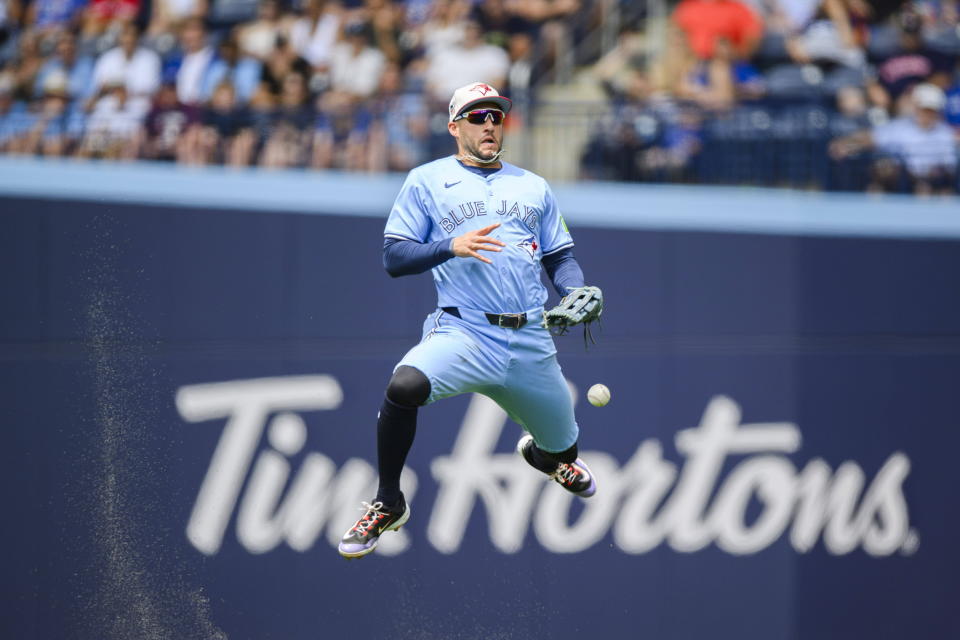 Toronto Blue Jays outfielder George Springer (4) misplays a single hit by Houston Astros second baseman Jose Altuve during the second inning of a baseball game against the Houston Astros, in Toronto on Thursday, July 4, 2024. (Christopher Katsarov/The Canadian Press via AP)