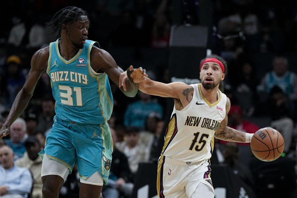 New Orleans Pelicans guard Jose Alvarado brings the ball down court against Charlotte Hornets center Nathan Mensah during the first half of an NBA basketball game Friday, Dec. 15, 2023, in Charlotte, N.C. (AP Photo/Chris Carlson)