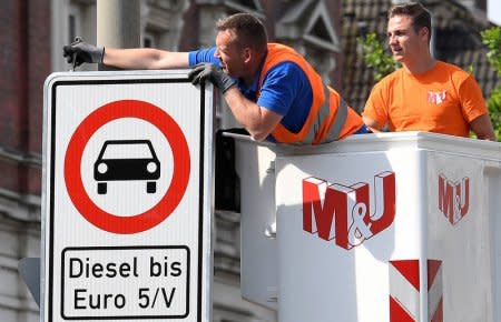 FILE PHOTO: Traffic signs which ban diesel cars are installed by workers at the Max-Brauer Allee in downtown Hamburg, Germany May 16, 2018. REUTERS/Fabian Bimmer/File Photo