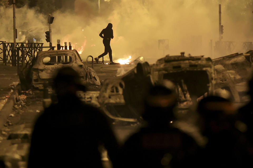 FILE - A demonstrator runs on the third night of protests sparked by the fatal police shooting of a 17-year-old driver in the Paris suburb of Nanterre, France, Friday, June 30, 2023. After more than 3,400 arrests and signs that the violence is now abating, France is once again facing a reckoning. (AP Photo/Aurelien Morissard, File)