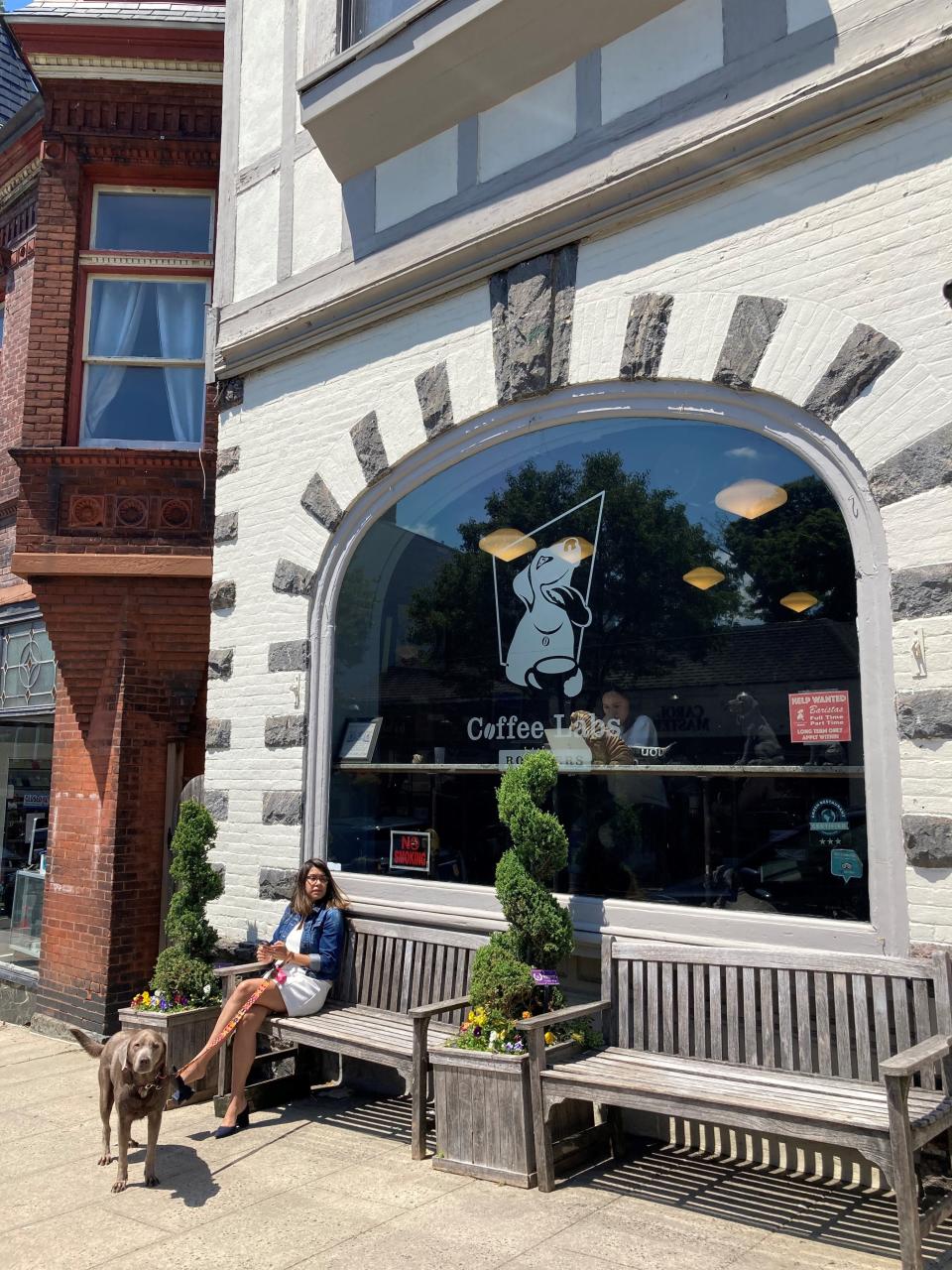 A woman and her dog outside Coffee Lab Roasters in Tarrytown. The coffeehouse has a lab as its mascot. Photographed June 6, 2022.