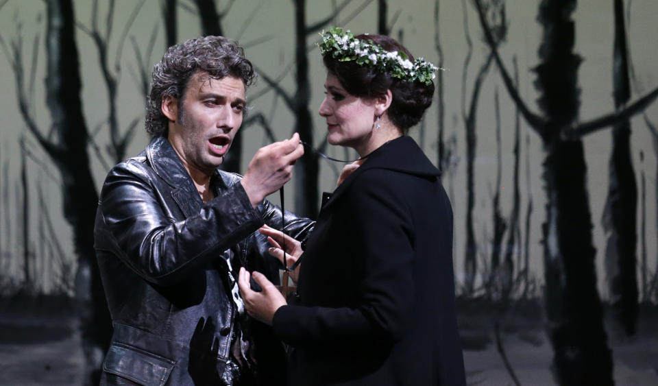 In this picture taken Friday, June 21, 2013, Jonas Kaufmann, left, in the role of Manrico and Anja Harteros as Leonora sing during a dress rehearsal for the opera "Il Trovatore" by Giuseppe Verdi in the Bavarian State Opera House in Munich, southern Germany. This wild new production by Olivier Py opened the company's annual Munich Opera Festival. It's a non-stop barrage of nightmarish images mixing styles and periods that assault the audience at lightning speed on a multi-tiered revolving set. (AP Photo/Matthias Schrader)