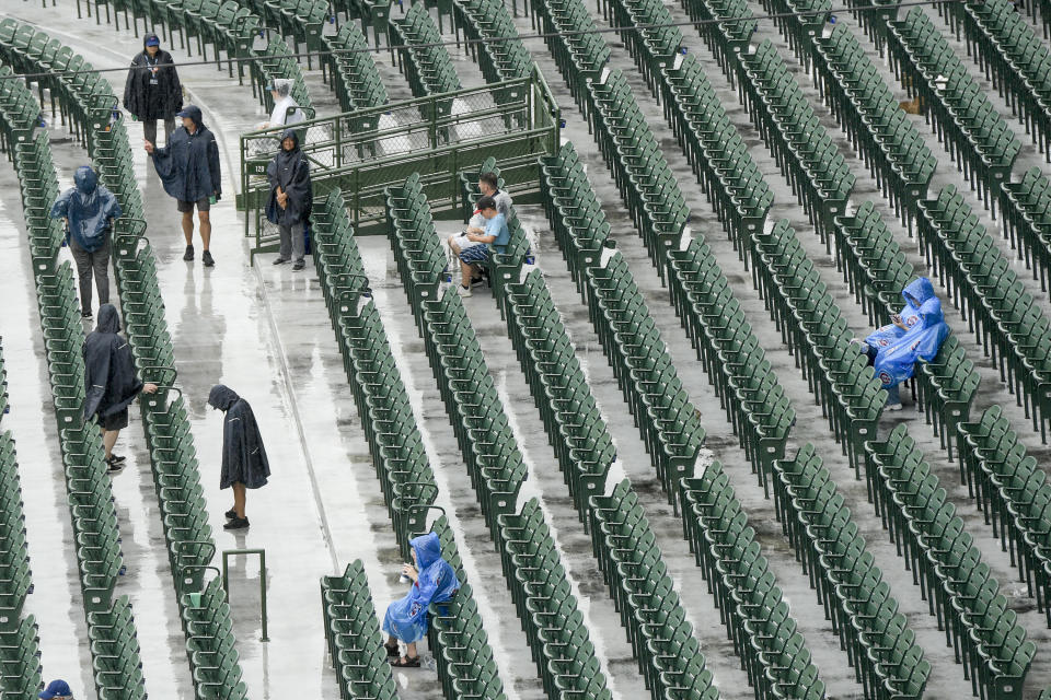 Some fans wait out a rain-delayed baseball game between the Chicago Cubs and the Miami Marlins, Sunday, Aug. 7, 2022, at Wrigley Field in Chicago. (AP Photo/Mark Black)