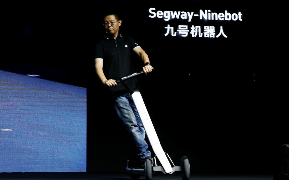 Ninebot president Wang Ye riding one of the firm's new KickScooter T60 scooters - REUTERS