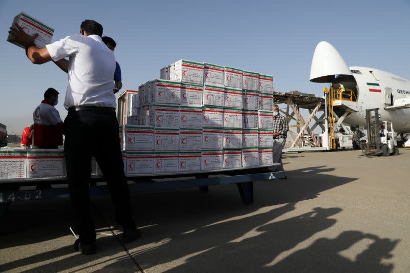 Cargo personnel works in a loading operation of Iran's humanitarian aid to Lebanon after the massive blast in Beirut, at Mehrabad Airport west of Tehran