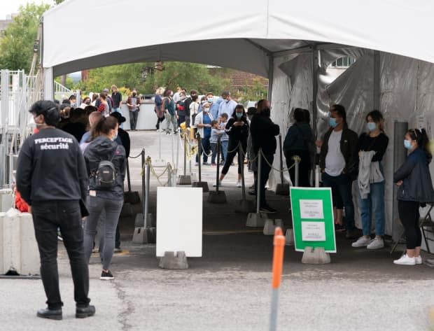 People lineup at a COVID-19 testing clinic Wednesday. Cases are on the rise in Montreal. (The Canadian Press - image credit)