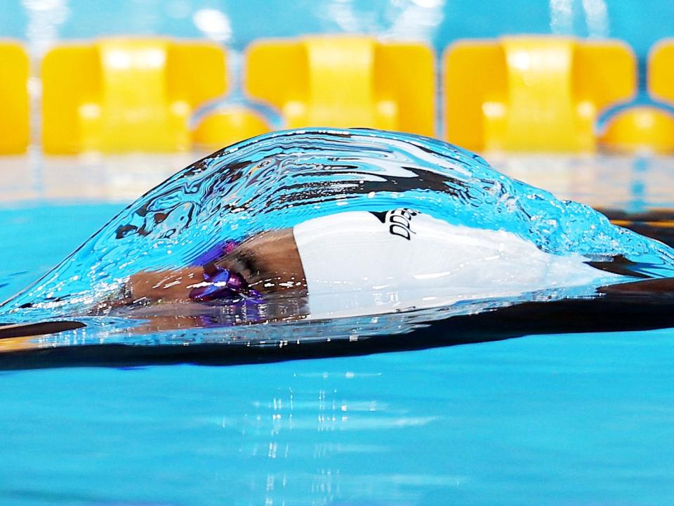 A water bubble forms around a swimmer coming to the surface at the Tokyo Olympics.