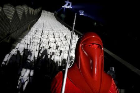 A fan dressed as a character from "Star Wars" poses for a photo in front of five hundred replicas of the Stormtrooper characters at the Juyongguan section of the Great Wall of China during a promotional event for "Star Wars: The Force Awakens" film, on the outskirts of Beijing, China, October 20, 2015. REUTERS/Jason Lee