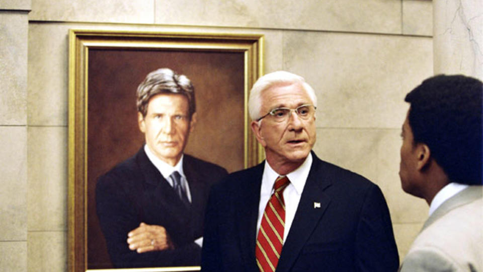 Leslie Nielsen als US-Präsident vor einem Abbild seines Vorgängers: Harrison Ford