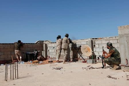 Fighters from forces aligned with Libya's new unity government fire a weapon from atop a house, on an Islamic State position in the Zaafran area in Sirte June 30, 2016. REUTERS/Ismail Zitouny