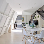 first level of the loft featuring a kitchen, dining table and chairs and a staircase