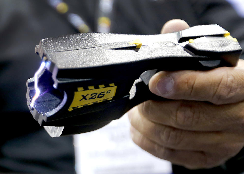 G Squared Consulting CEO Alex Solis demonstrates an electroshock weapon at the 8th annual Border Security Expo, Tuesday, March 18, 2014, in Phoenix. The two day event features panel discussions, sharing intelligence, and exhibitors displaying high-tech wares aimed at securing lucrative government contracts and private sales. G Squared Consulting creates clothing that is resistant to electroshock weapons. (AP Photo/Matt York)