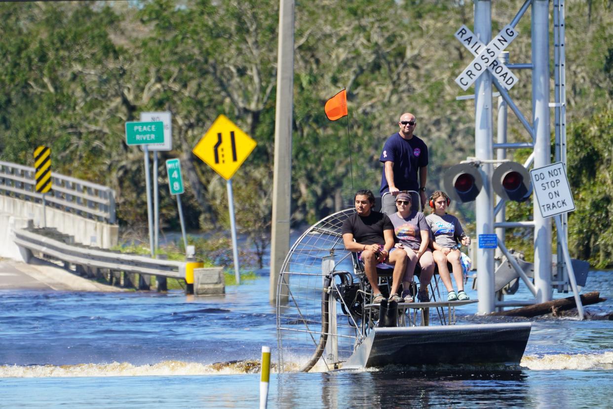 An airboat captain evacuates people from flooded areas of DeSoto County, Florida, on Sunday, Oct. 2, 2022, following the passage of Hurricane Ian.