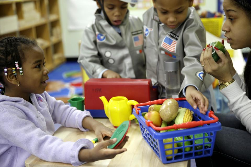 FILE - In this Tuesday, Jan. 21, 2014 file photo, Oumou Balde, 4, left, plays with her teacher Jacqualine Sanchez, right, and pretend food in a pre-kindergarten class at the Sheltering Arms Learning Center in New York in a program to educate children about nutrition and health. According to a study published Tuesday, Jan. 25, 2014 in the Journal of the American Medical Association, researchers found that obesity among children ages 2 to 5 dropped - to 8 percent, from 14 percent a decade ago. (AP Photo/Seth Wenig, File)