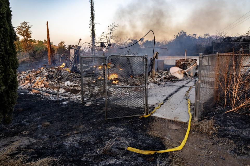 The Juniper fire continues to smolder inside the remains of a home off Santa Rosa Mine Road.