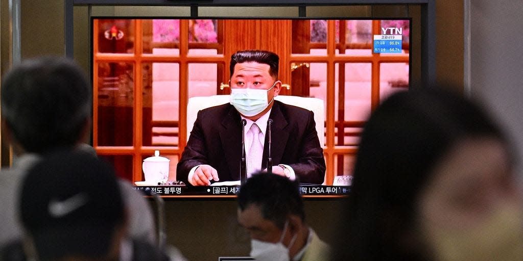 People sit near a screen showing a news broadcast at a train station in Seoul on May 12, 2022, of North Koreas leader Kim Jong Un.