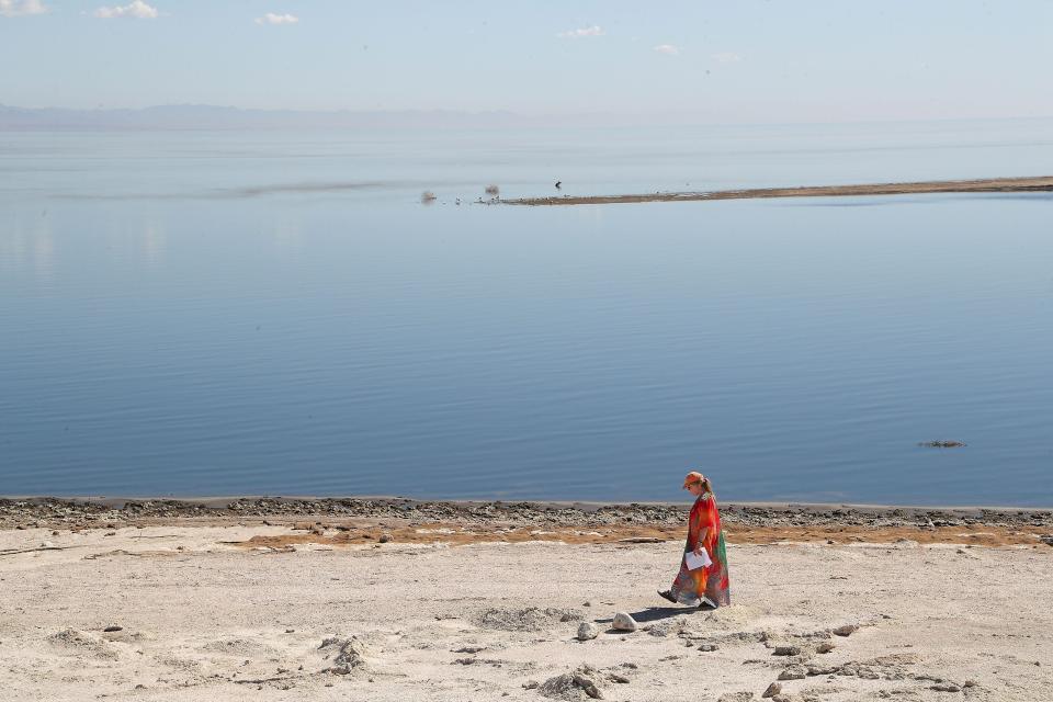 A woman takes a spiritual walk in October 2022 along the shoreline of the Salton Sea in Desert Shores, Calif..