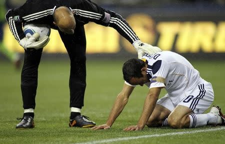 Seattle Sounders FC goalkeeper Kasey Keller (L) checks on Los Angeles Galaxy captain and midfielder Landon Donovan after the two players collided during the first period of their MLS season opener at Qwest Field in Seattle, March 15, 2011. REUTERS/Anthony Bolante