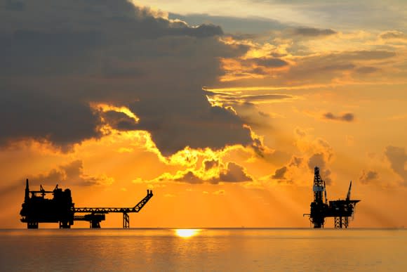 An oil rig and platform at sunset