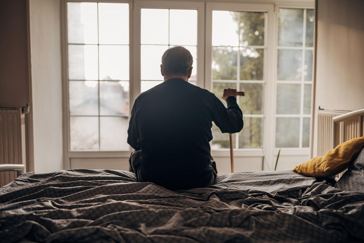 Lonely old man sitting on bed Getty Images/Nes