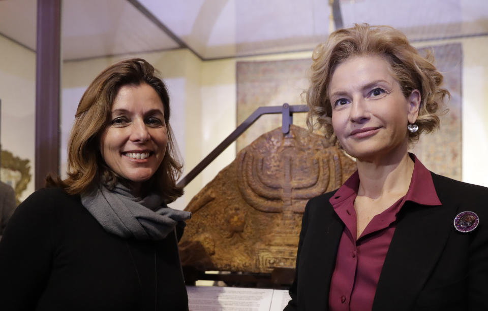 Director of the Vatican Museums, Barbara Jatta, left, and Director of Rome's Jewish Museum Alessandra Di Castro pose for a photo in front of a bas-relief showing a menorah at the end of a press conference in Rome, Monday, Feb. 20, 2017. The Vatican and Rome Jewish community are teaming up for the first- ever joint exhibit by the two institutions' museums. Focus will be the menorah, the candelabra depicted in both Jewish and Catholic art over the centuries. (AP Photo/Alessandra Tarantino)