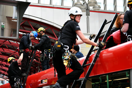 Police takes away protester Phil Kingston, 83, during a demonstration blocking traffic at Canary Wharf Station during the Extinction Rebellion protest in London, Britain April 25, 2019. REUTERS/Dylan Martinez