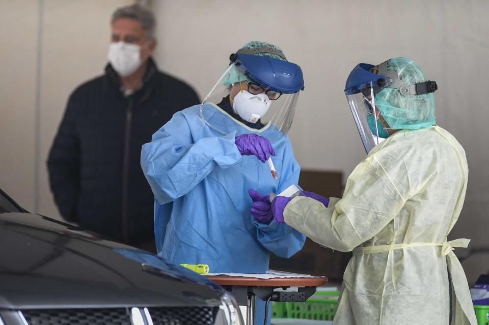 Members of the Michigan State University health care team place a specimen into a bag they'll send to Sparrow Hospital's lab for COVID-19 testing, Wednesday, April 1, 2020. MSU researchers have developed a new test they hope to get approval for from the FDA.