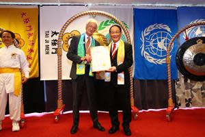 Dr.  Hong, Tao-Tze, president of FOWPAL, presents a Certificate to Dr.  Aldo Manos, former director of the United Nations Environment Program, for ringing the Bell of World Peace and Love on June 3, 2022 during Stockholm + 50.