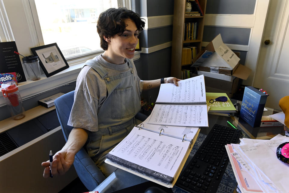 Grayson Hart, who directs a youth theater program, reviews sheet music at the Ned R. McWherter West Tennessee Cultural Arts Center in Jackson, Tenn., on Saturday, March 4, 2023. Hart is among hundreds of thousands of young people who came of age during the pandemic but didn’t go to college. Many have turned to hourly jobs or careers that don’t require a degree, while others have been deterred by high tuition and the prospect of student debt. (AP Photo/Mark Zaleski)