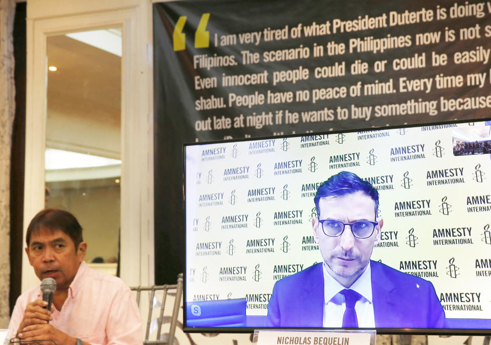 Butch Olano, Amnesty International Section Director in the Philippines, left, and Nicholas Bequelin, Regional Director for East and Southeast Asia, (on screen) answer questions from the media during a tele-news conference Monday, July 8, 2019, in Manila, Philippines. Amnesty International has urgently called for international pressure and an immediate U.N. investigation to help end what it says are possible crimes against humanity in the Philippine president's bloody anti-drug crackdown.(AP Photo/Bullit Marquez)