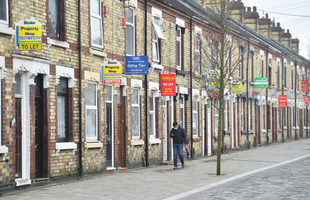 STOKE-ON-TRENT, ENGLAND - MARCH 03: A man walks past a street of terraced houses advertising properties To Let on March 03, 2021 in Stoke-on-Trent, England. UK Chancellor, Rishi Sunak, announced the return of 95% mortgages to help first-time buyers. He also announced that house buyers would be exempt from paying stamp duty for a further three months with the scheme ending on 31st June 2021. (Photo by Nathan Stirk/Getty Images)