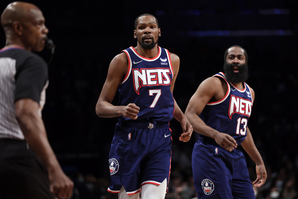 Brooklyn Nets forward Kevin Durant (7) and James Harden (13) react toward an official during the first half of an NBA basketball game against the Milwaukee Bucks, Friday, Jan. 7, 2022, in New York. (AP Photo/Adam Hunger)