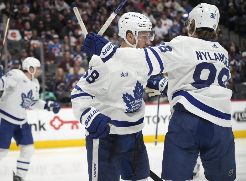 Toronto Maple Leafs left wing Michael Bunting, front left, is congratulated after scoring a goal by right wing William Nylander in the second period of an NHL hockey game against the Colorado Avalanche, Saturday, Dec. 31, 2022, in Denver. (AP Photo/David Zalubowski)