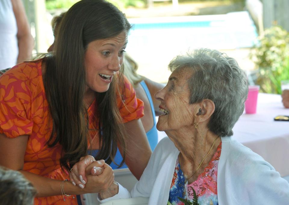 Lindsay McCarthy, of Canton, left, greets her great-aunt, Jo Sharp, right, during her 100th birthday celebration at her Braintree home.